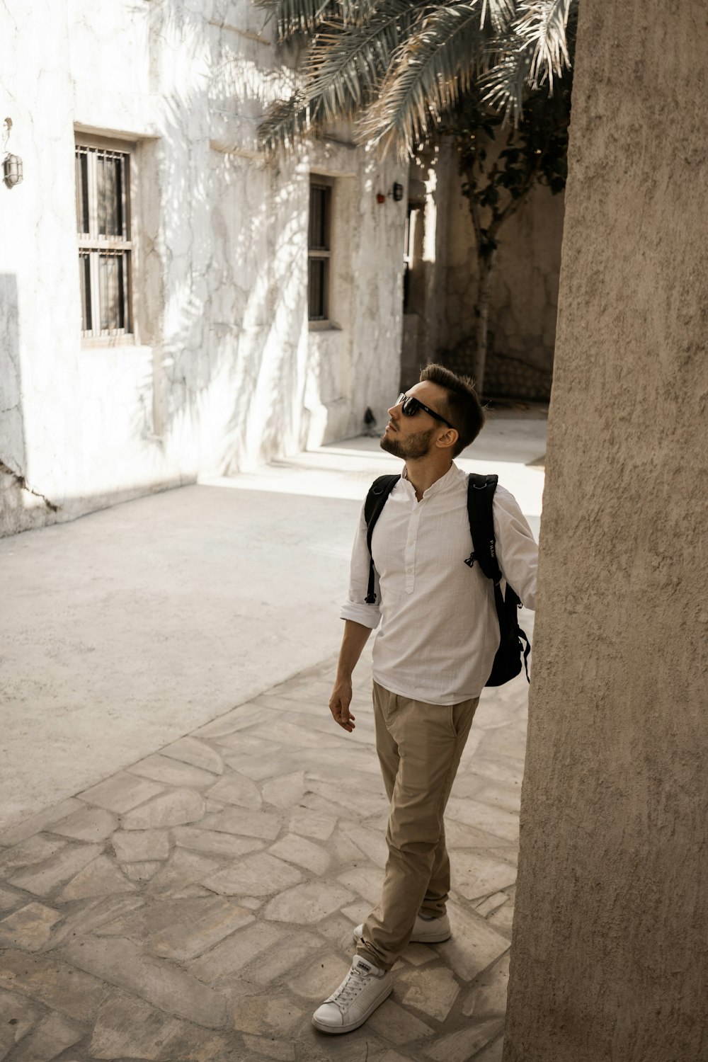 a man standing next to a tall pillar