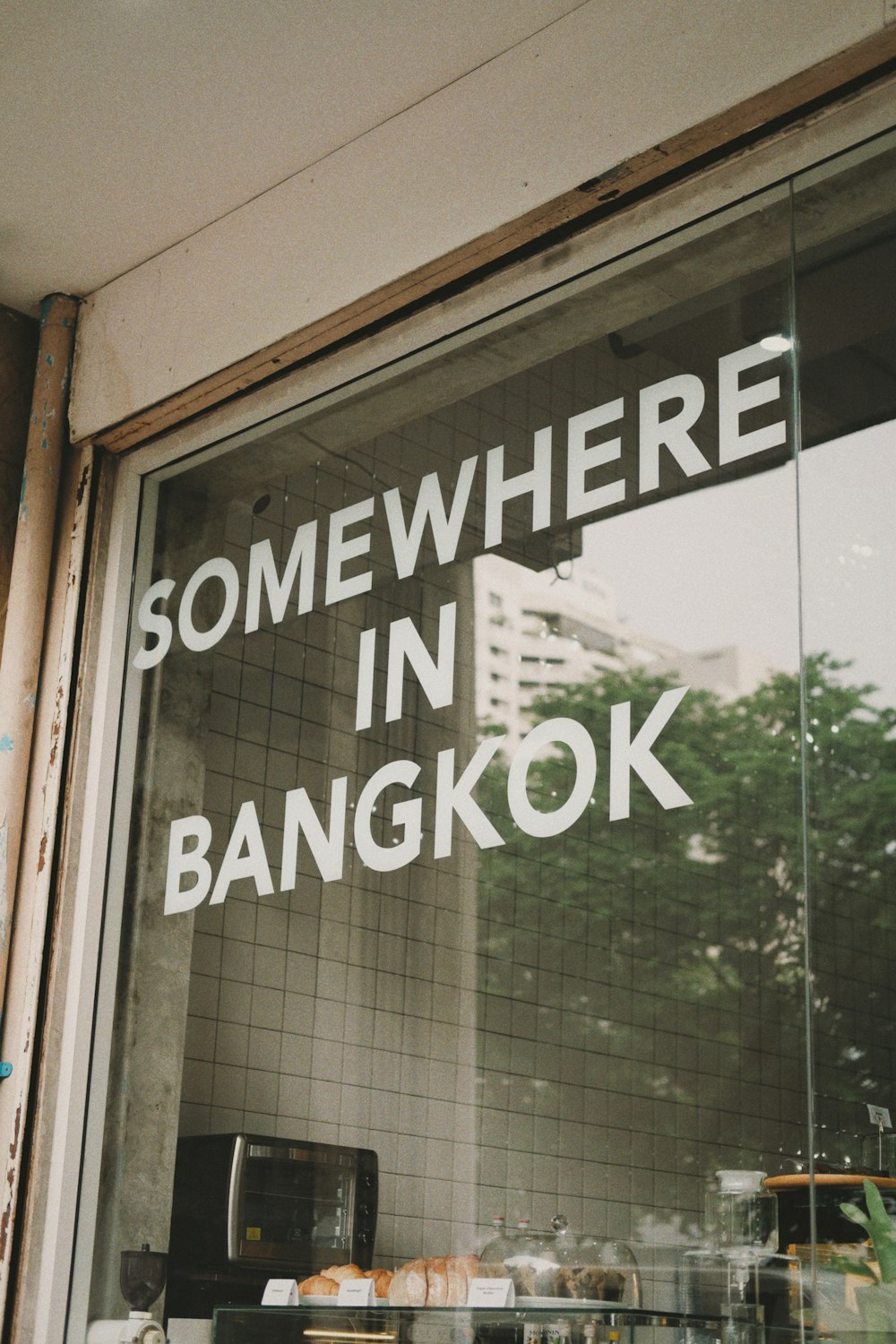 a window with a sign that says somewhere in bangkok