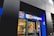 A storefront with a modern design, featuring a vibrant blue sign with the letters 'RBC' on it. Below 'RBC', large letters spell out 'on campus', with a glass door entrance. Inside, the interior appears well-lit with a warm, inviting atmosphere. The number '35' is visible on the glass, and signage with information is displayed.