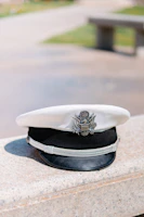 A casual outdoor scene showing someone wearing a cap embroidered with a small dove emblem.