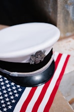 a white hat sitting on top of an american flag