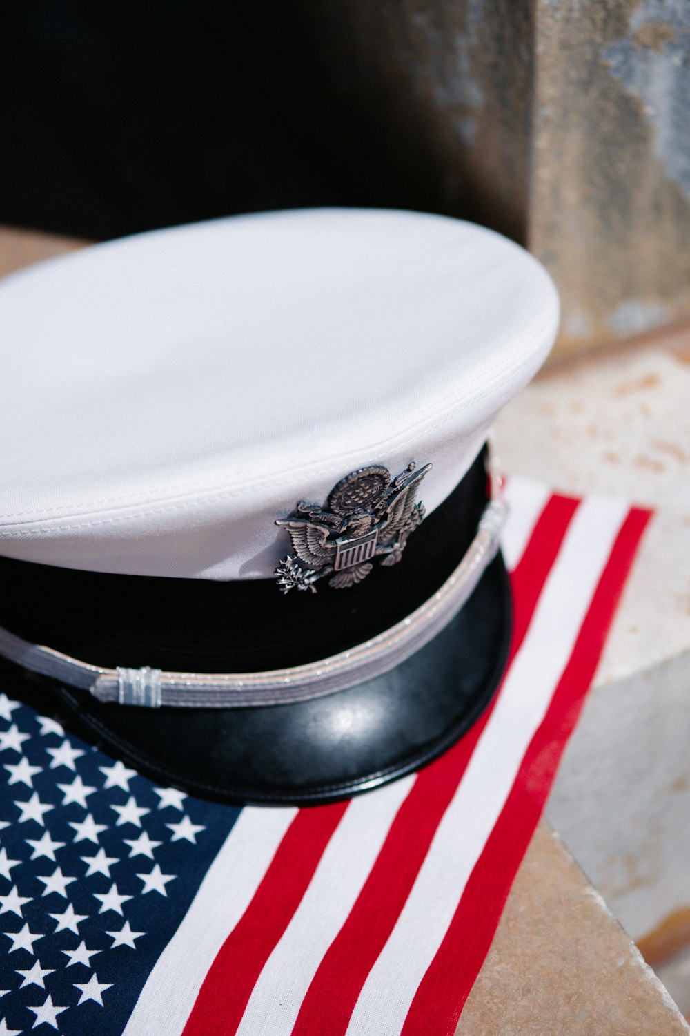 a white hat sitting on top of an american flag