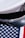 A white naval officer's cap with an emblem rests on an American flag that features blue with white stars and red and white stripes.