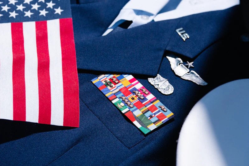 Military uniform folded next to an American flag