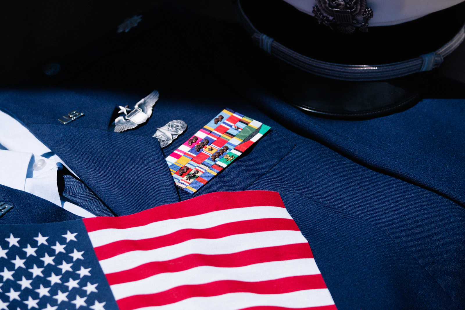 Navy blue dress uniform with US flag and ribbons.