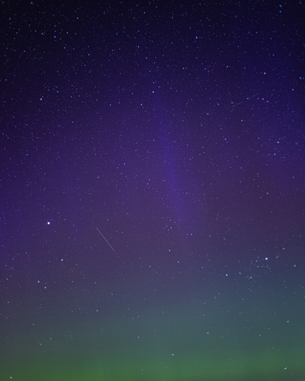 a green and purple sky filled with stars