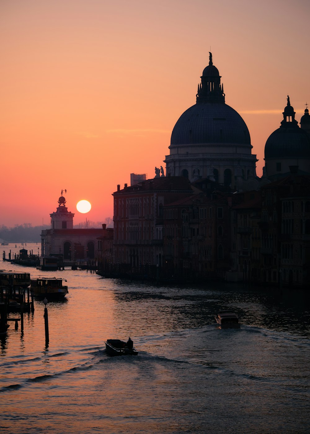 a boat traveling down a river next to tall buildings