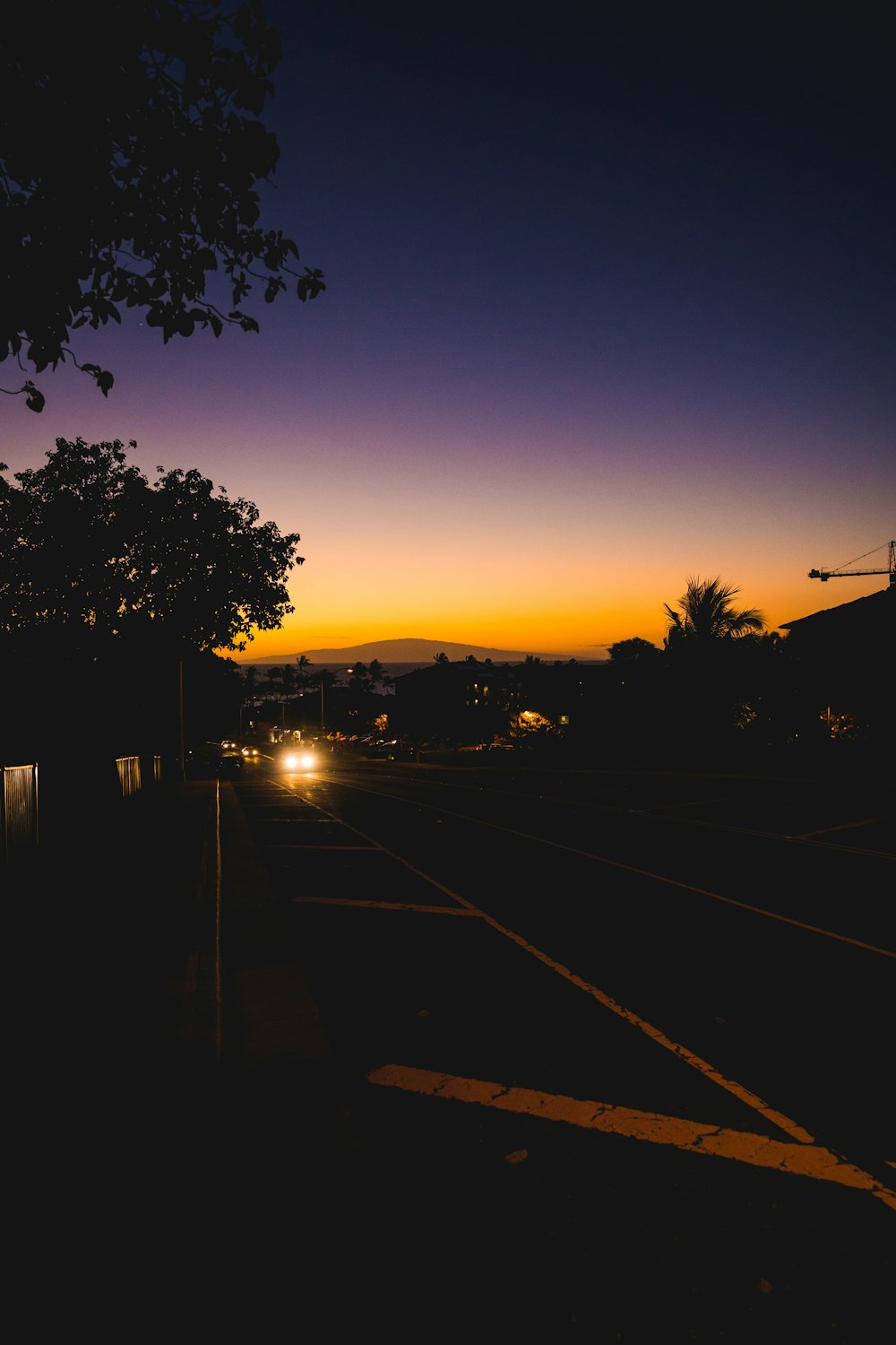 the sun is setting over a city street