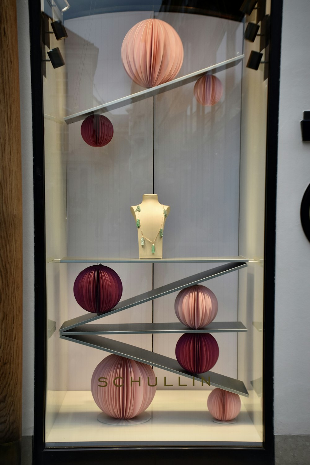 a display case filled with pink and white paper lanterns