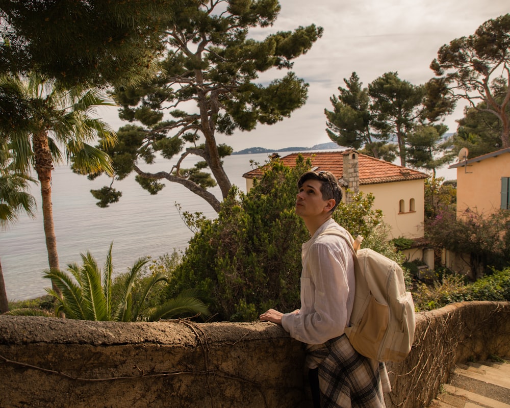 a man standing on a stone wall next to a body of water