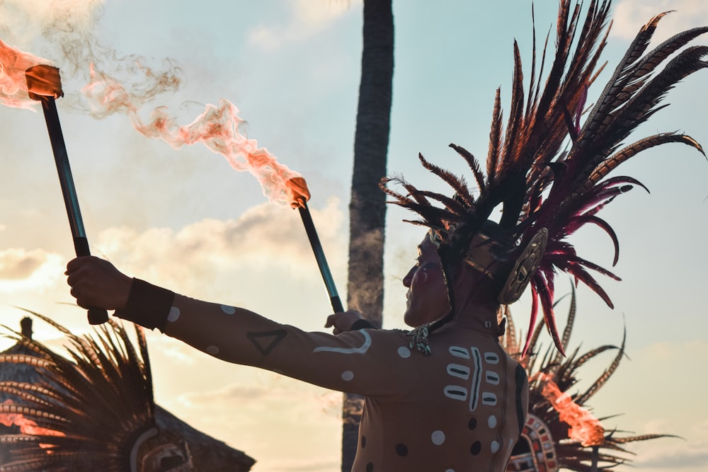 a man in a native american costume holding a stick