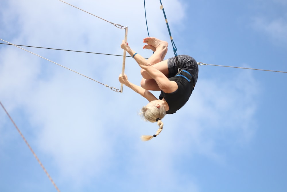 a woman on a rope high up in the air