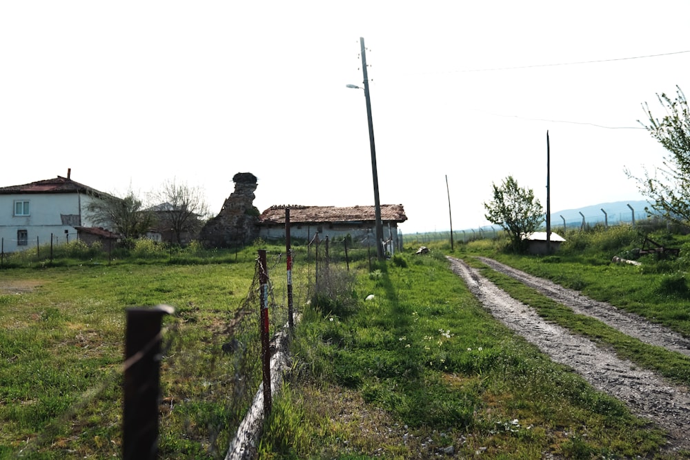 a fenced in field with a house in the background