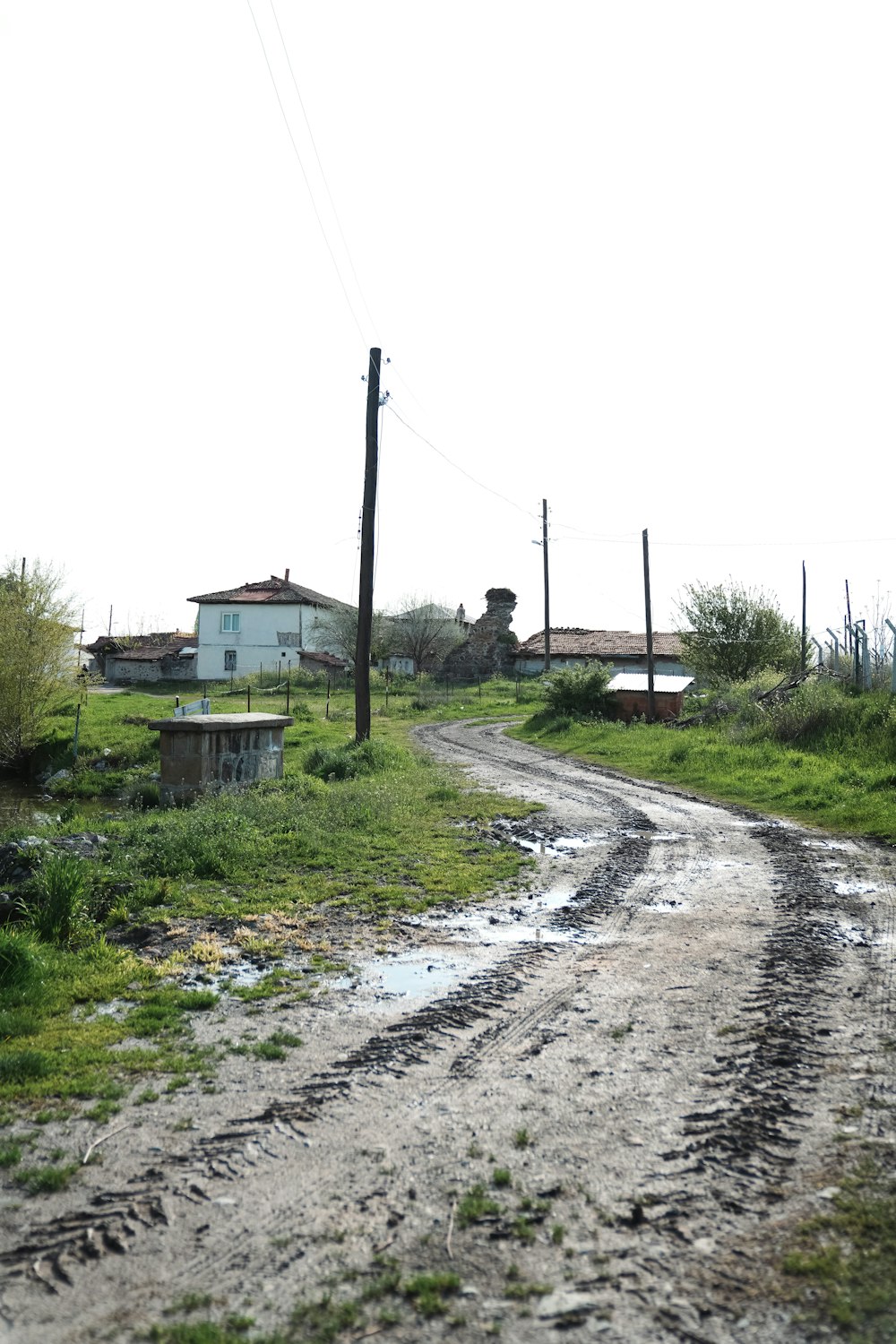 a dirt road with a house in the background