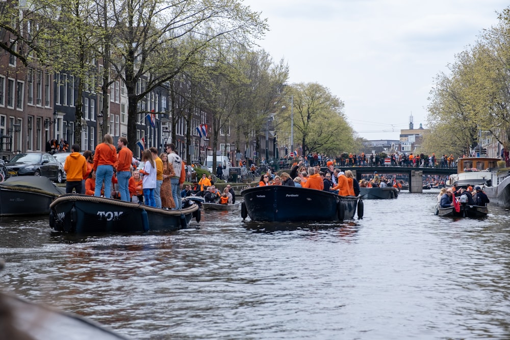 a group of people riding on top of boats down a river