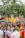 A lively and colorful parade with multiple people holding signs advocating for LGBTQ+ rights and equality. The crowd is diverse, with rainbow flags and vibrant outfits, contributing to a festive and inclusive atmosphere.