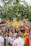 A lively and colorful parade with multiple people holding signs advocating for LGBTQ+ rights and equality. The crowd is diverse, with rainbow flags and vibrant outfits, contributing to a festive and inclusive atmosphere.