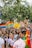 A lively and colorful parade with multiple people holding signs advocating for LGBTQ+ rights and equality. The crowd is diverse, with rainbow flags and vibrant outfits, contributing to a festive and inclusive atmosphere.