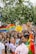 A lively and colorful parade with multiple people holding signs advocating for LGBTQ+ rights and equality. The crowd is diverse, with rainbow flags and vibrant outfits, contributing to a festive and inclusive atmosphere.
