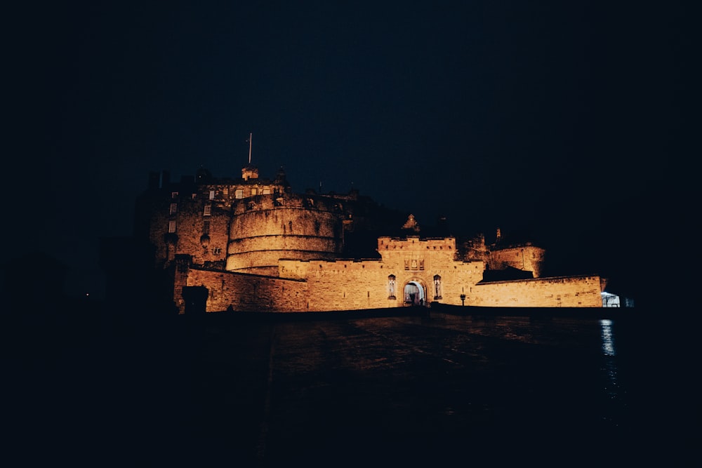 a castle lit up in the dark at night
