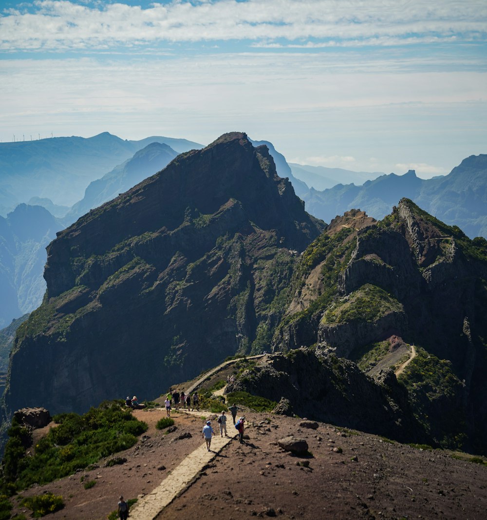 a group of people walking up the side of a mountain