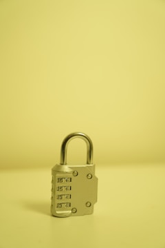 a padlock on a table with a yellow background