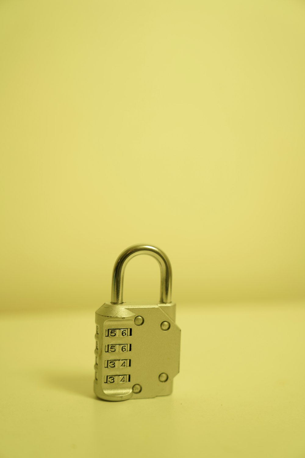 a padlock on a table with a yellow background