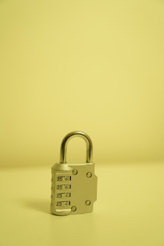 A padlock against a bright yellow background, representing the locked-down nature of safe deposit box access during banking crises