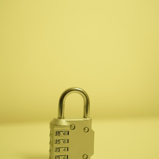 a padlock on a table with a yellow background