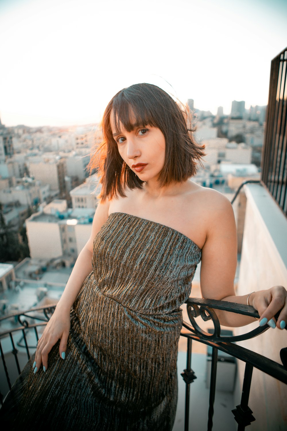 a woman in a dress standing on a balcony