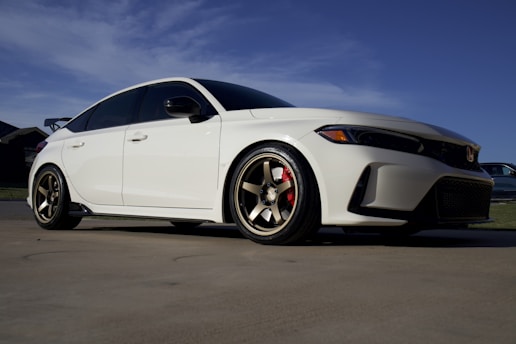 A sleek car parked under the Arizona sun with freshly tinted windows reflecting a blue sky.