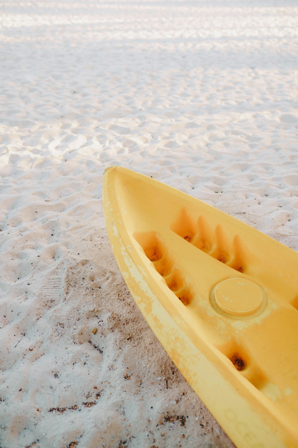 a yellow kayak sitting on top of a sandy beach