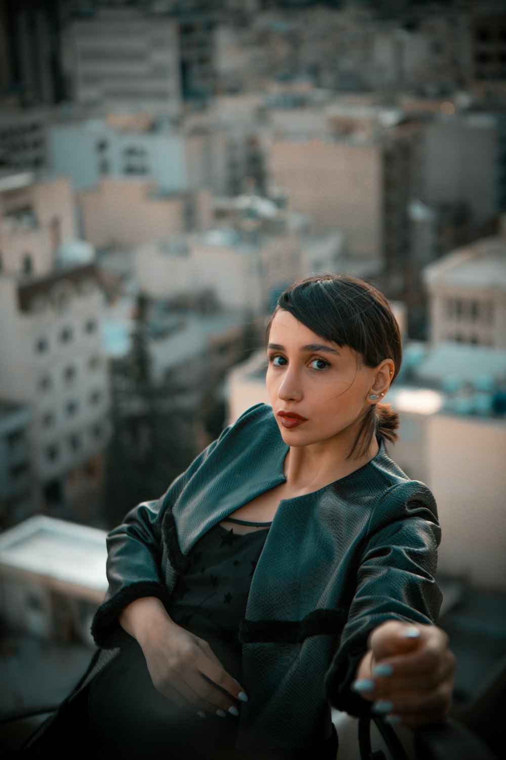 a woman in a leather jacket looking at the camera