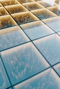 A geometric pattern of illuminated squares, each containing intricate light patterns, creating a modern and futuristic appearance.