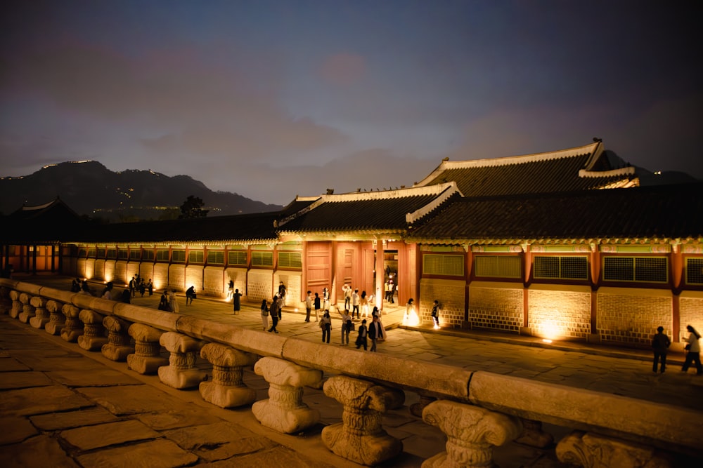 a group of people standing outside of a building at night