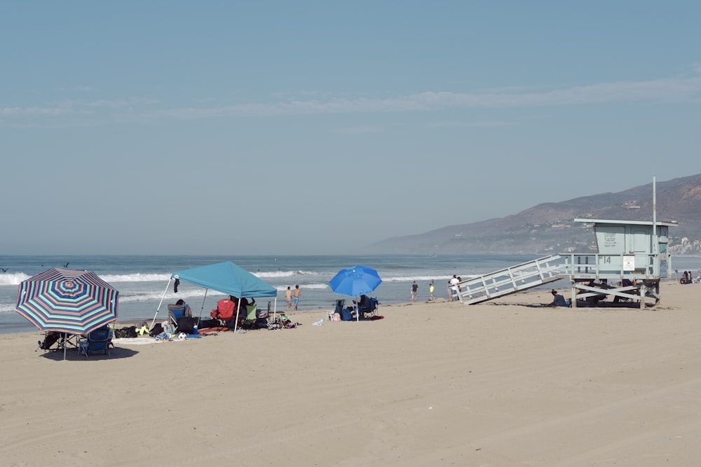 un groupe de personnes assises au sommet d’une plage de sable