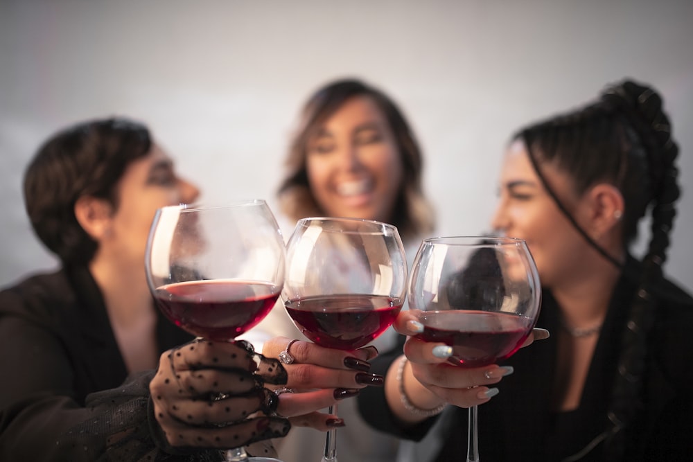 a group of women holding up wine glasses