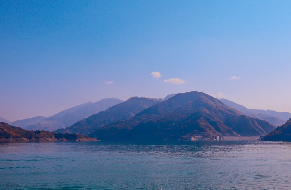 a body of water with mountains in the background