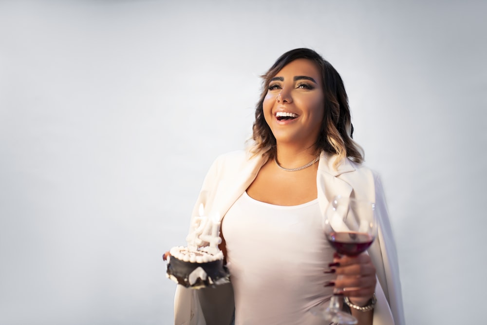 a woman holding a glass of wine and smiling