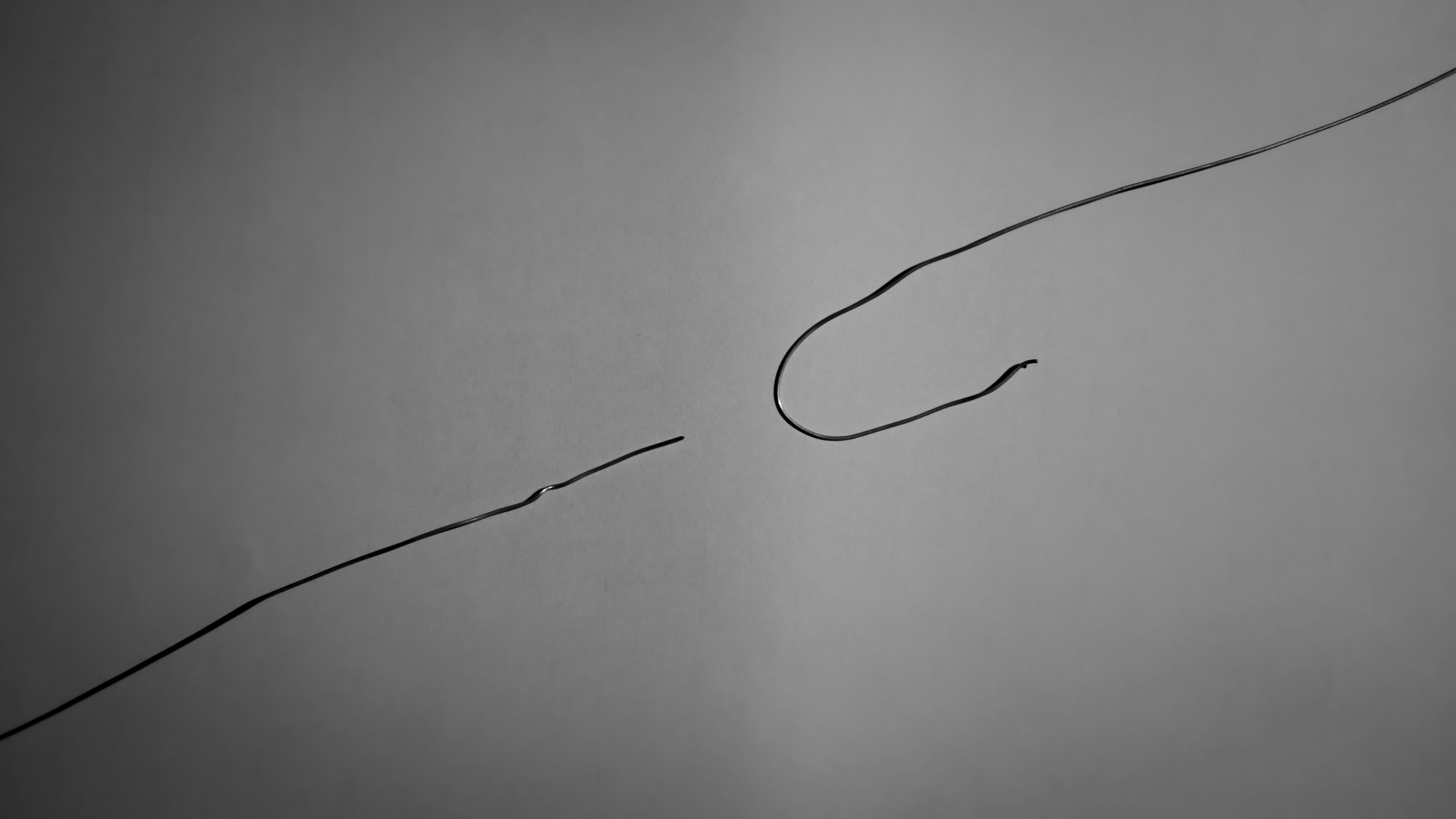 a black and white photo of a kite flying in the sky