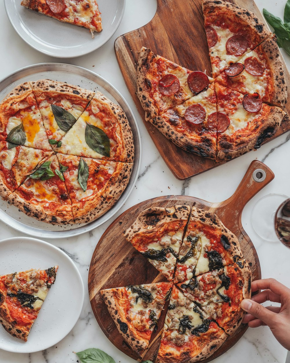 a table topped with pizzas and plates of pizza