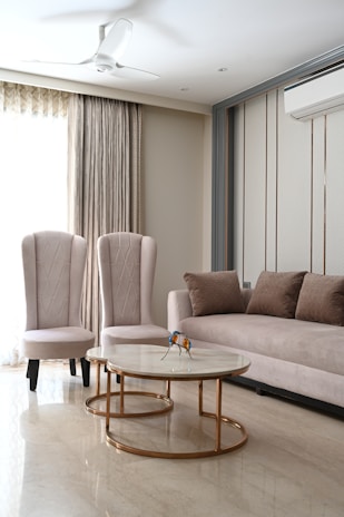 Interior living room featuring smooth, flawless beige walls accented by gold trim and modern lighting.