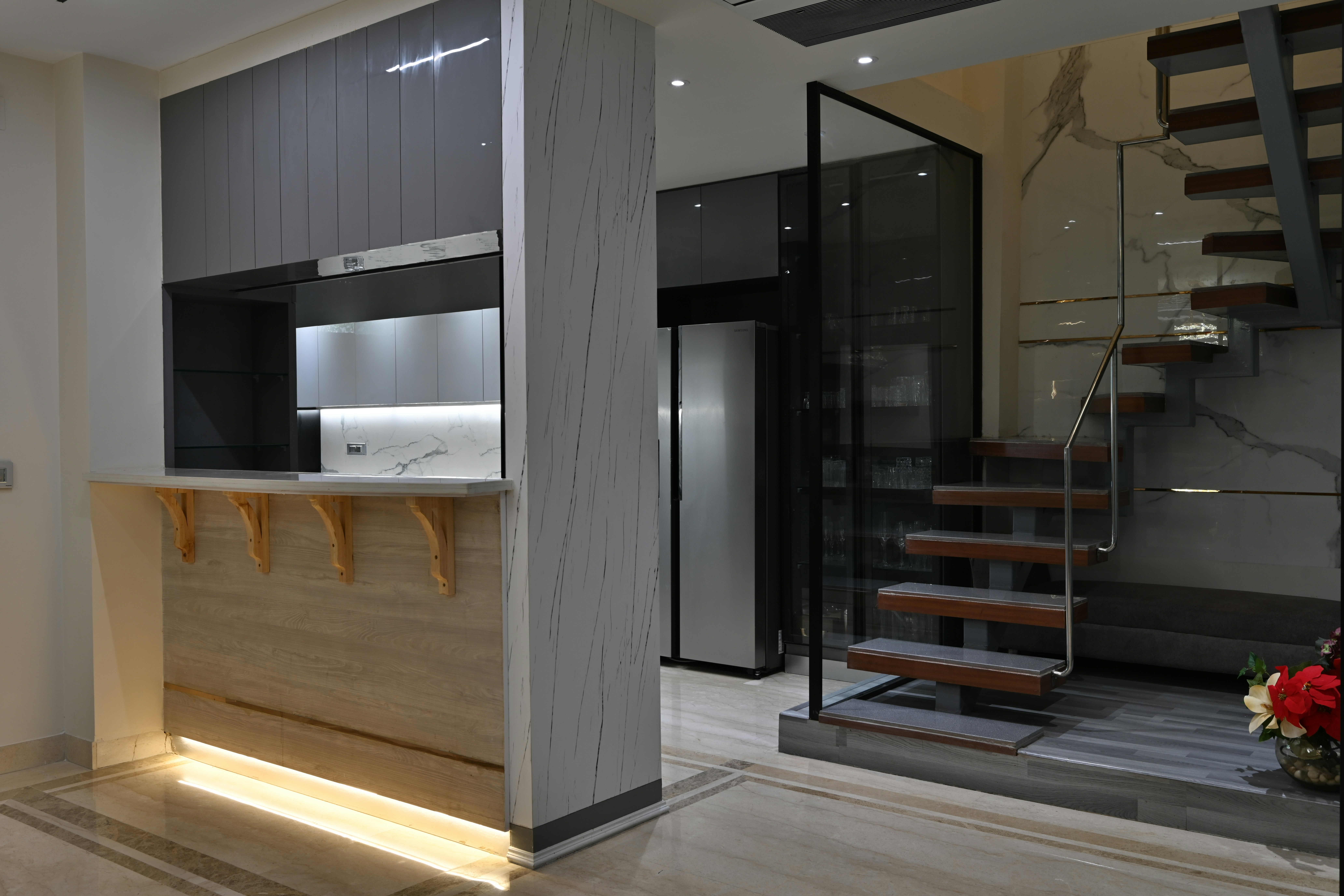 a kitchen with a staircase leading to the upper floor