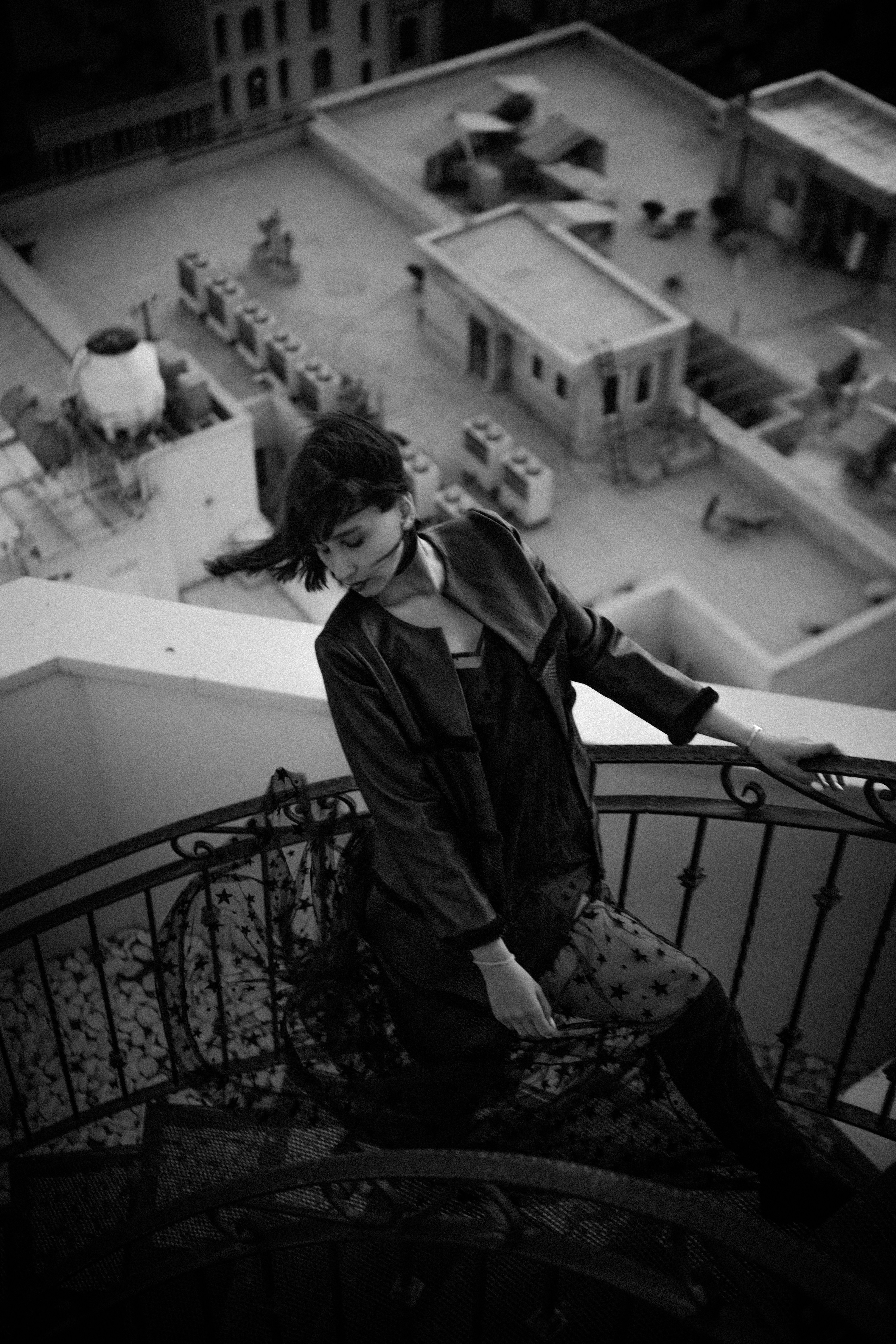 a woman sitting on top of a metal railing