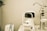 A white optometry machine is situated on an examination table, used for eye testing, alongside other medical equipment in a clinical setting. The background is neutral with smooth walls.