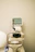 A medical device is positioned against a plain background. The machine features a screen displaying various icons and controls, likely for diagnostic purposes, and an apparatus for eye examination.