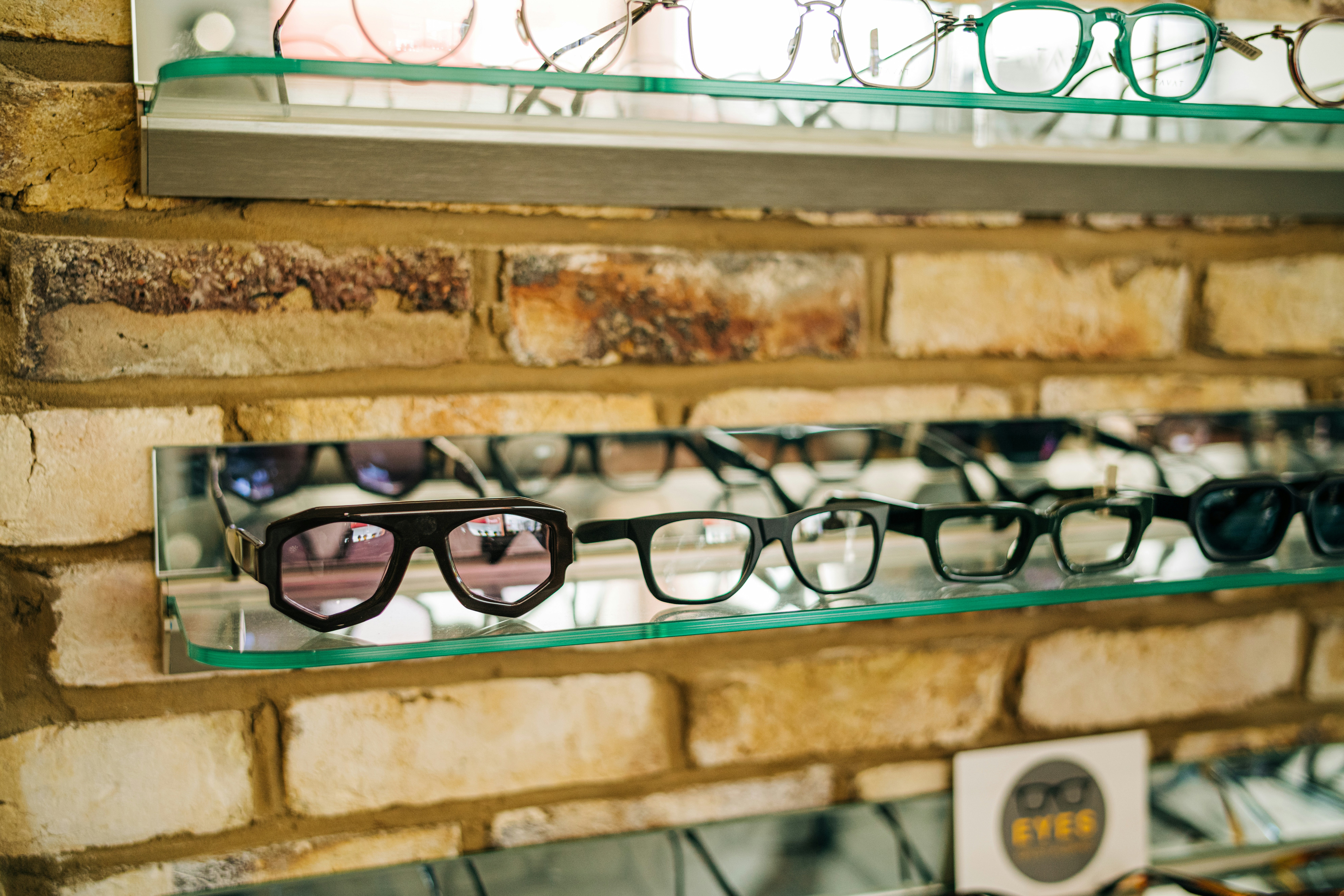 a brick wall with several pairs of glasses on display
