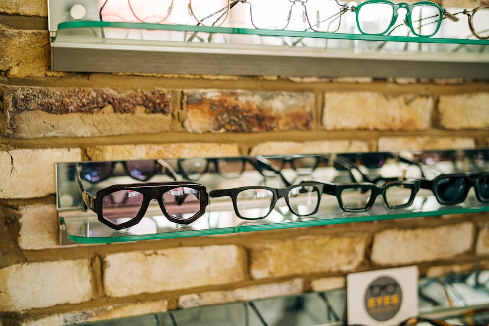 a brick wall with several pairs of glasses on display