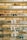 Multiple shelves filled with a variety of eyeglasses are mounted on a brick wall. The glasses are arranged neatly, showcasing different styles and colors, including frames in yellow, green, blue, and black. A small sign reading 'EYES' is placed on some of the shelves.