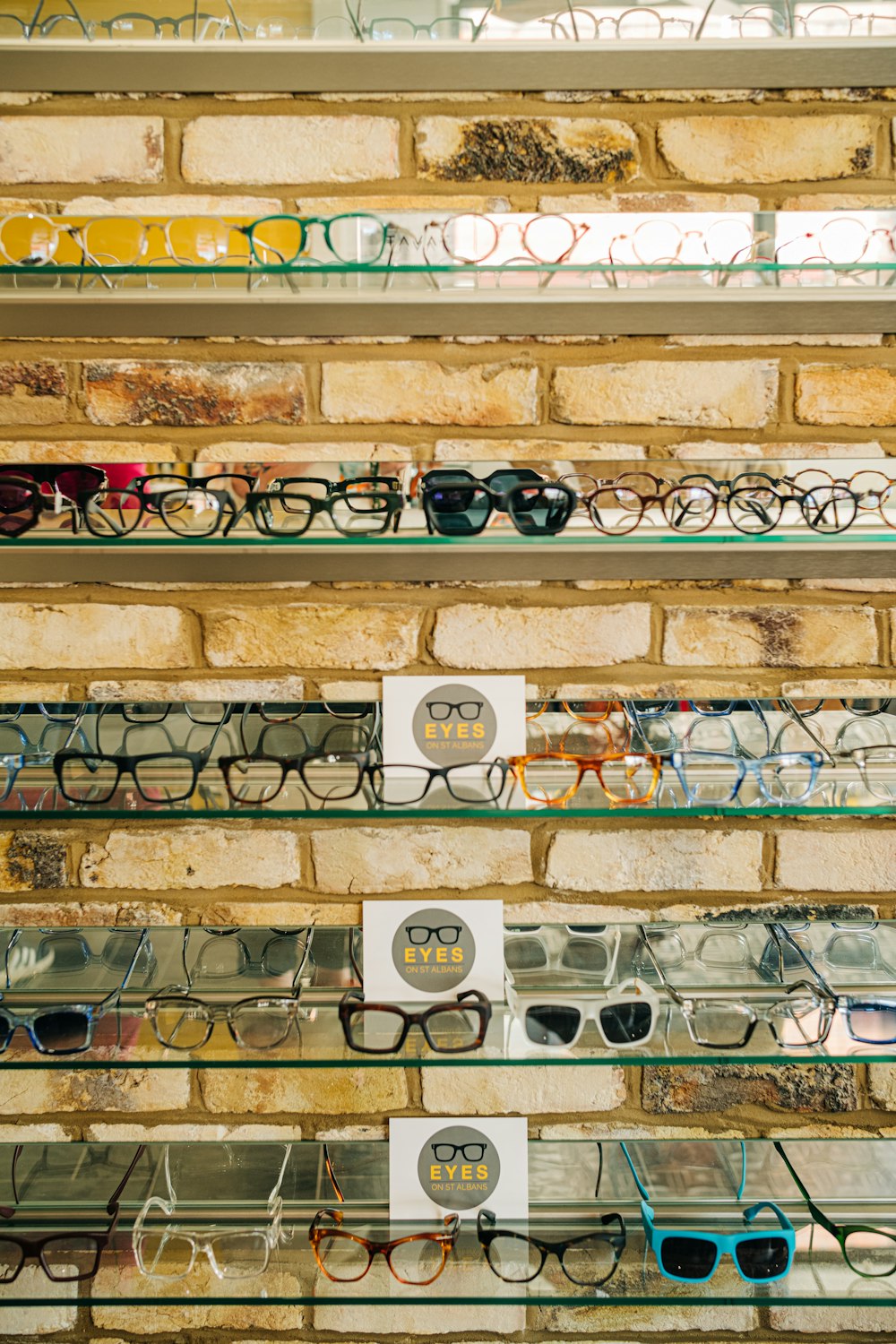 a display of glasses on a brick wall